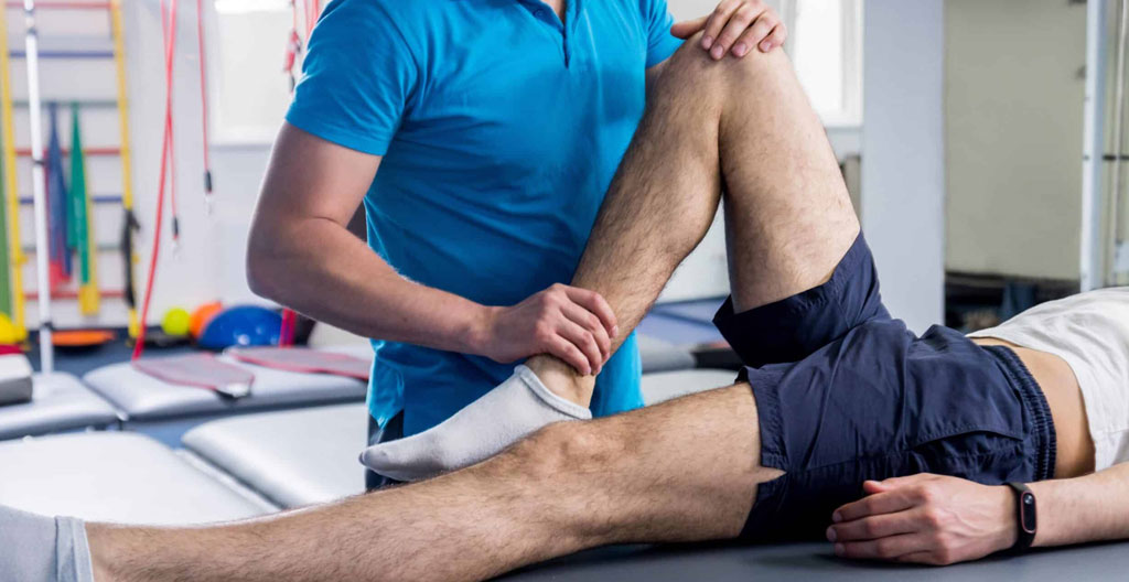 A contemporary physiotherapy room with rehabilitation equipment including parallel bars and therapy aids in natural lighting